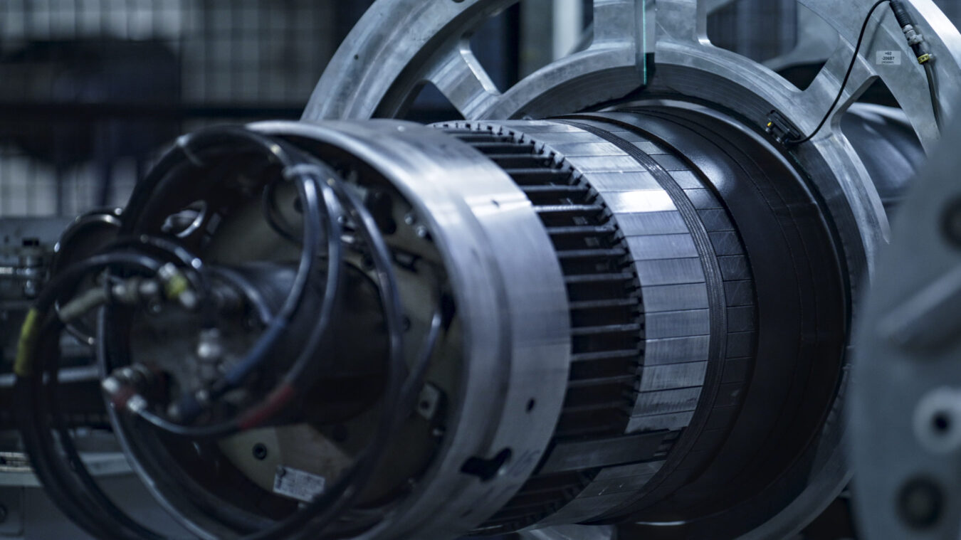 778556 Volta - Barcelona Noticias 24h Close-up of a large turbine rotor with metallic rings and cables in an engineering workshop, showing exposed blades and hardware.